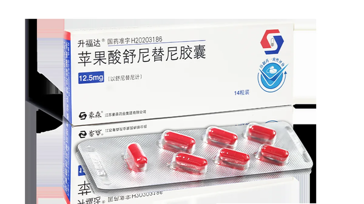 患者手持舒尼替尼50mg处方和药盒，背景是医院药房窗口